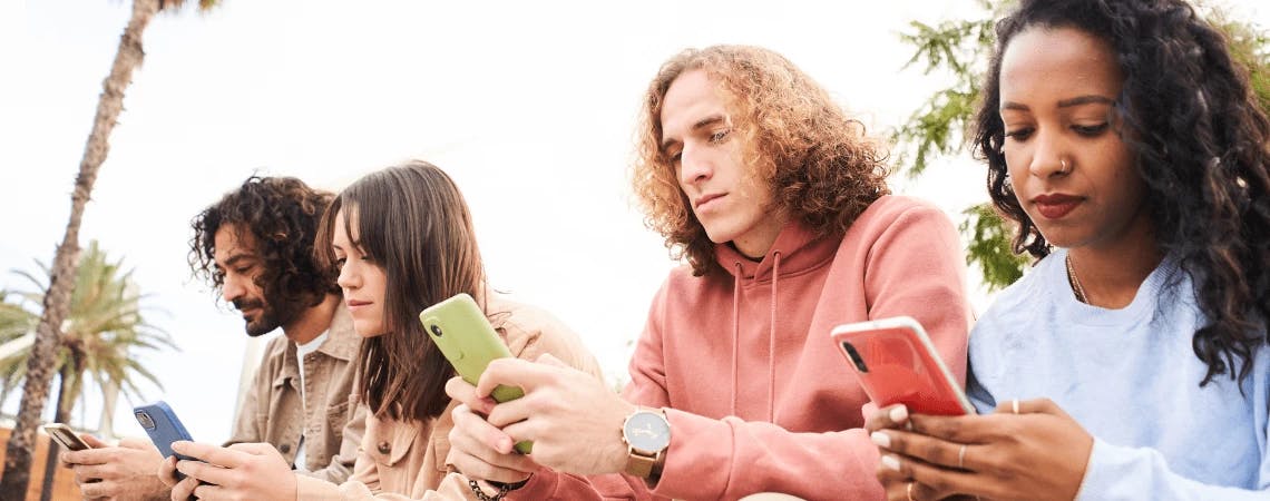 Imagem de um grupo de jovens testando site mobile em seus celulares.